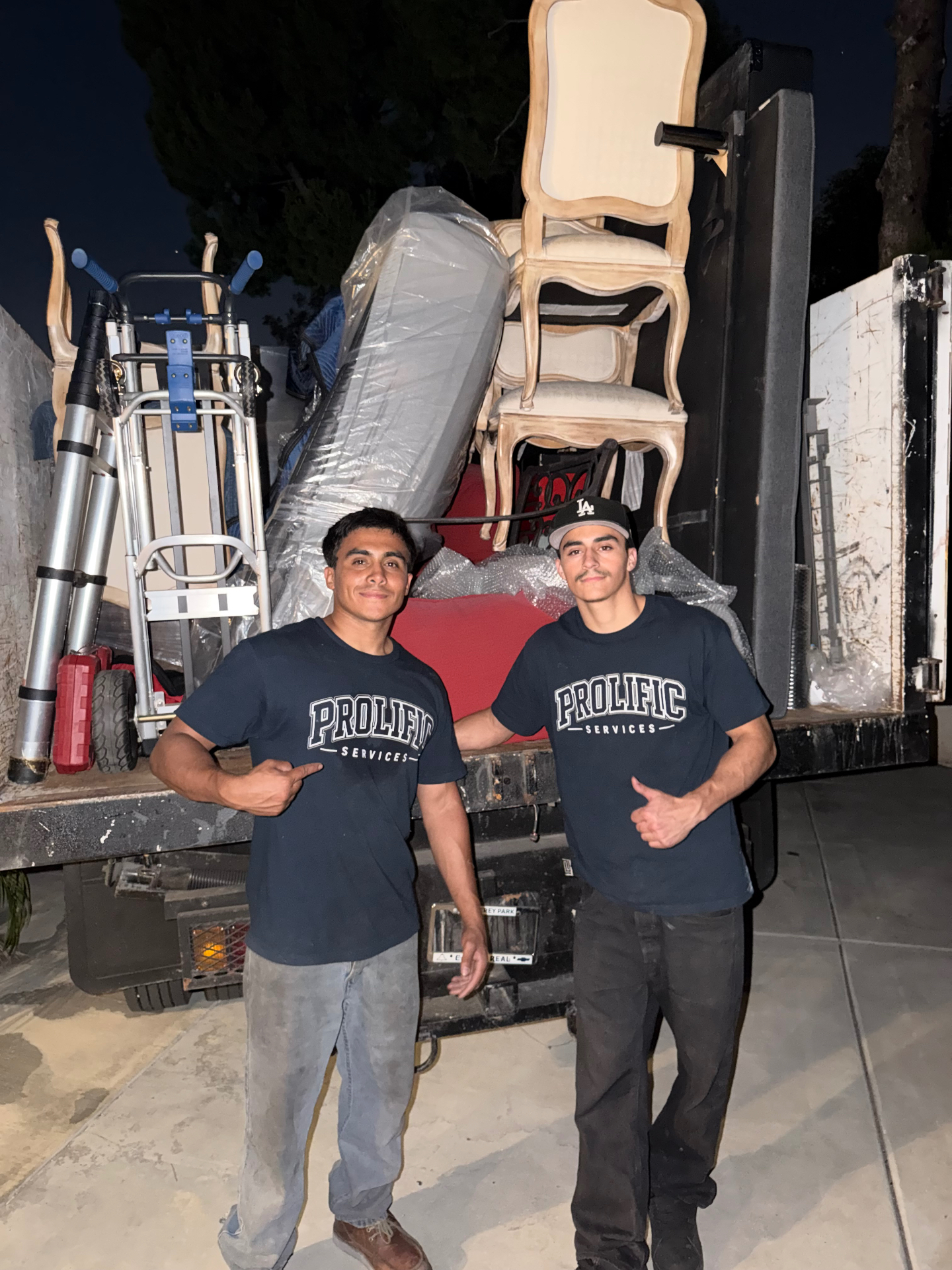 Prolific Services crew standing in front of a fully loaded moving truck